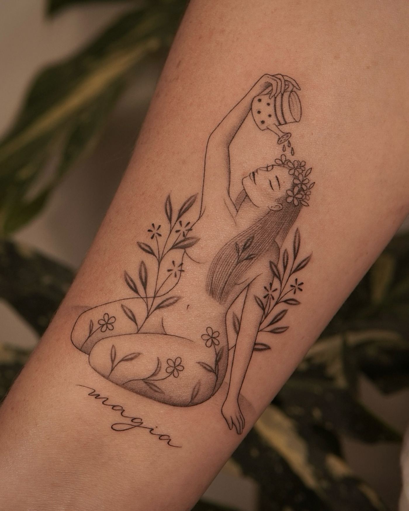 Tatuaje fine line en blanco y negro de una figura femenina regando flores entre plantas, antebrazo